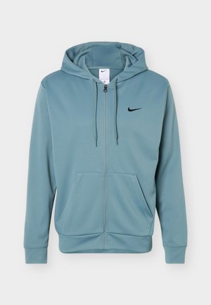 Ανοιχτό μπλε φούτερ Nike με φερμουάρ, κουκούλα με κορδόνια, τσέπες μπροστά και μαύρο λογότυπο Nike swoosh στο αριστερό στήθος.