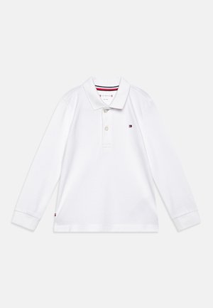 Polo à manches longues blanc en coton, doté d'un col, d'une patte de boutonnage à trois boutons et d'un logo discret sur la poitrine.