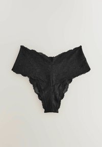 Black lace women's underwear with floral pattern and scalloped edges on a light background.