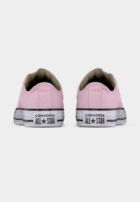 Ζευγάρι ροζ sneakers Converse All Star χαμηλού τύπου, εμφανισμένα από πίσω σε λευκό φόντο.
