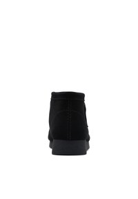 Botines de ante negro con un tacón bajo, que presentan una forma redondeada simple y costuras en contraste a lo largo de las costuras.