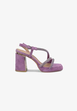 Sandale en suede violet avec un embout carré, des brides entrecroisées, des accents en métal argenté et un large talon bloc métallique.