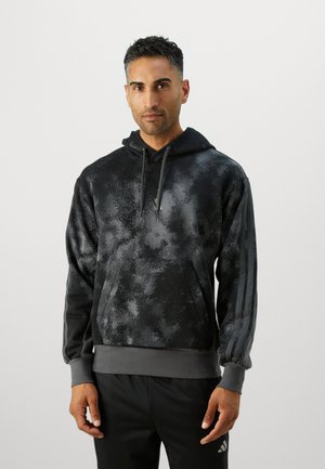 Sudadera negra con un patrón abstracto gris, que cuenta con un bolsillo frontal, capucha con cordón, y puños y dobladillo grises a juego; tres rayas en las mangas.
