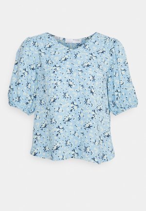Blusa floral azul claro com mangas bufantes, gola redonda e um corte largo, adornada com padrões florais brancos e azuis marinhos.