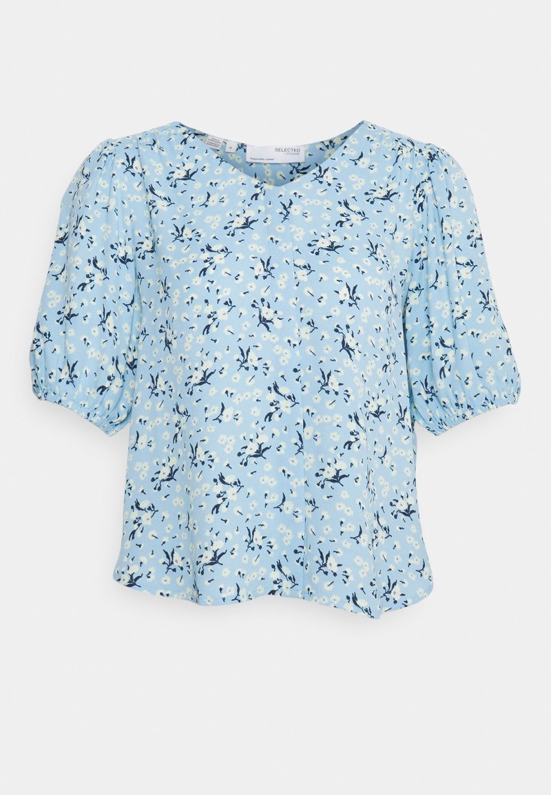 Blusa floral azul claro com mangas bufantes, gola redonda e um corte largo, adornada com padrões florais brancos e azuis marinhos.