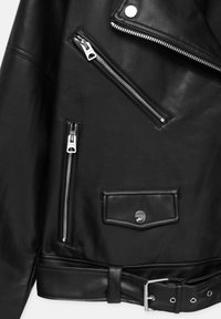 Giacca da motociclista nera in pelle con tre cerniere argentate, un flap della tasca con bottone a scatto e una cintura con fibbia argentata all'orlo.