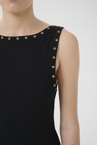 Top de alças preto com textura canelada, apresentando detalhes em ilhós prateados ao longo da gola e dos ombros. Com uma textura suave, design ajustado e estilo sem mangas.