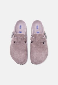 Ζευγάρι ανοιχτό καφέ σουέντ μοκασίνια τύπου clog με ρυθμιζόμενο λουράκι και αγκράφα, μέγεθος 38, από ψηλά πάνω σε λευκό φόντο.