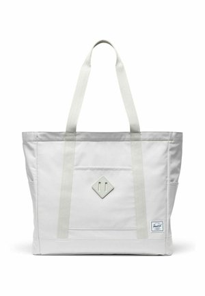Sac fourre-tout blanc avec longues poignées, poche avant, écusson en forme de losange et petite étiquette de marque rectangulaire en bas à droite.