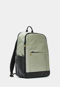 Zaino rettangolare in grigio chiaro e nero, realizzato con materiale resistente, presenta una tasca frontale con zip e un tirazip giallo.