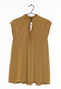 Ruskotinen lyhythihainen paita, jossa on korkea kaula-aukko, avainrei'itys ja nyörit kaula-aukossa. Valmistettu sileästä ja kevyestä kankaasta. Roikkuu koukussa.