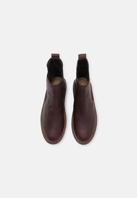 Stivali Chelsea in pelle bordeaux con lati elasticizzati e altezza alla caviglia. Texture liscia con punte arrotondate e dettagli di cucitura in contrasto.