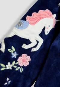 Tela de forro de color azul marino con bordado de un unicornio blanco, que presenta una melena rosa, silla de montar azul, estrellas plateadas y diseños florales en colores pastel.