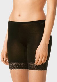 Shorts noirs en tissu doux et léger, avec un ourlet en dentelle décoratif. Conçus pour le confort avec une taille lisse.