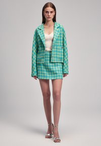 Set di blazer e gonna a scacchi turchesi, con design cropped, tessuto testurizzato e accenti in metallo argentato.