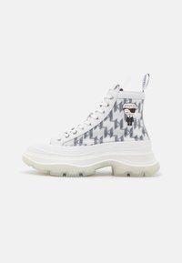 Sneakers alte con suola in gomma bianca, dettagli traslucidi e un motivo geometrico grigio. Presentano un dettaglio di personaggio dei cartoni animati sul lato.