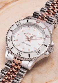 Orologio in acciaio inossidabile con quadrante argento e dettagli in oro rosato, dotato di una lunetta girevole, display a tre lancette e bracciale bicolore.