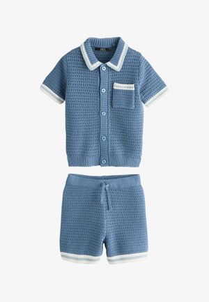 Chemise tricotée bleue à manches courtes avec boutons, bordure blanche et shorts assortis avec cordon de serrage et bordure blanche aux ourlets.