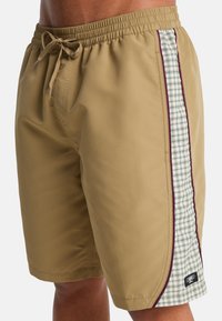 Μπεζ μαγιό με ελαστική μέση και κορδόνι, με πράσινη καρό πλαϊνή λωρίδα που περιβάλλεται από μπορντό λεπτομέρειες.