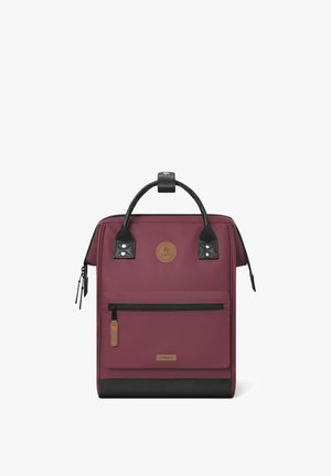 Bordeauxfarbene Rucksack mit schwarzen Akzenten, strukturiertem Boden, Oberhandgriff, vorderer Reißverschlusstasche und rundem Logopatch. Glatte Stoffoberfläche.