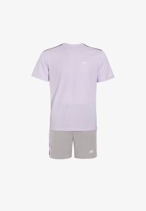 Heledad lilla lühikeste varrukatega spordisärk hallide lühikeste pükste kanssa. Omaduseks on ümmargune kaelus, kontrastsed triibud ja logo aktsendid.