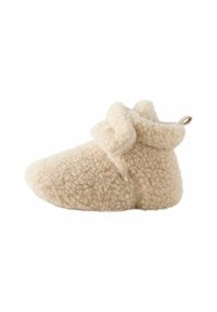 Chausson en peluche beige avec une surface douce et texturée, un bout arrondi et un revers replié. Il dispose d'une petite boucle pour un enfilage facile.