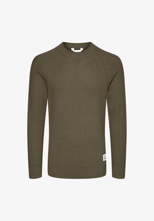 Olíva zöld bordás kötött pulóver hosszú ujjal, kerek nyakkivágással és oldalsó címkével. Az anyag textúrájú, a szabás pedig formázott.