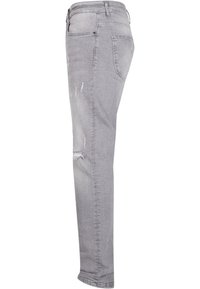 Harmaat farkut slim fit -mallilla. Edessä on kevyesti kulutettu ilme ja kapeneva lahje. Klassinen viisi taskua -design nappisulalla.