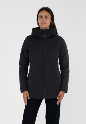 Giacca nera isolata con zip frontale, colletto alto e cappuccio regolabile. Presenta tasche laterali e una texture liscia e opaca.