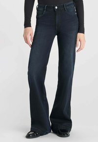 Donkerblauwe wijde jeans van denim, met vijf zakken, riemlussen en een knoopsluiting. Soepele textuur met minimale vervaging.