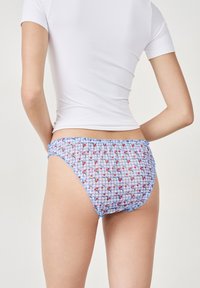 Bikini-Höschen mit blau-weißem Karomuster und roten Kirschakzenten, ausgestattet mit Rüschen und gerafftem Material, das eine enganliegende Form bietet.