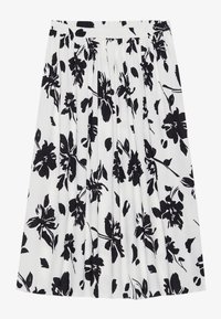 Jupe plissée avec un motif floral noir sur fond blanc. Elle a une taille élastique et un tissu texturé.