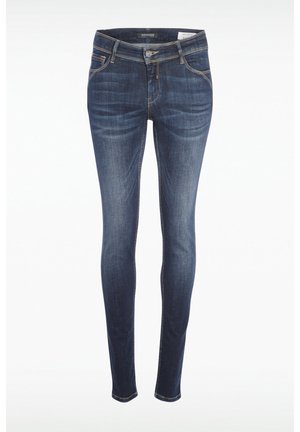 Jeans skinny en denim bleu foncé avec une texture lisse. Comprend cinq poches, une fermeture éclair et des accents de couture dorés le long des coutures.