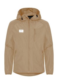 Huutopaita, vaalean beige, vetoketjulla edessä, kahdella vetoketjullisella taskulla ja joustavilla hihansuilla. Valmistettu kevyestä, vettä hylkivästä materiaalista.