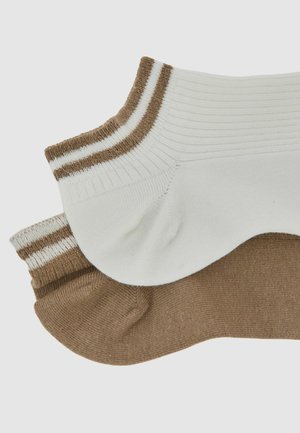 Kaks paari pahkluu sokke: üks valge pruunide triipudega, teine üleni pruun. Mõlemad on soonilise tekstuuriga ja ümara varbakujundusega.