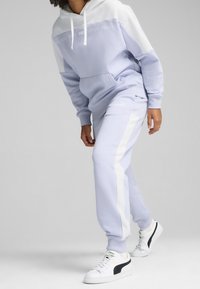 Lichtpaarse hoodie met witte accenten, voorzien van een kangoeroezak, gecombineerd met bijpassende sweatpants met witte zijstrepen en logo.