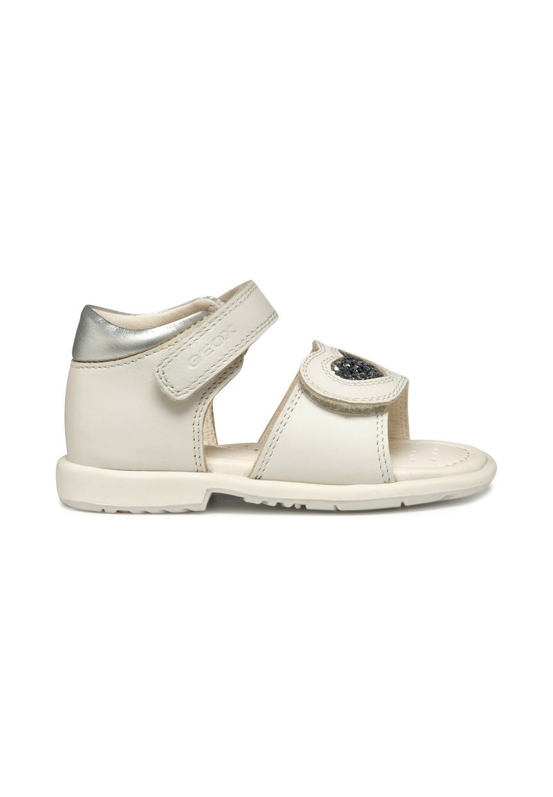 Witte leren sandalen met een zilveren accent, verstelbare band, open teen ontwerp, gestructureerde voetbed en decoratieve patch met versieringen.