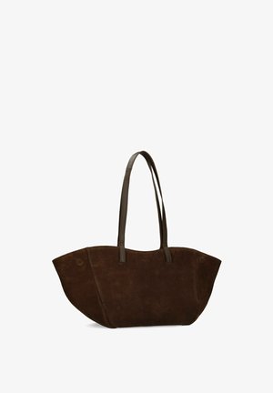 Dunkelbraune Wildleder-Shopper-Tasche mit langen Lederhenkeln und breiten, leicht geschwungenen Seiten vor weißem Hintergrund.