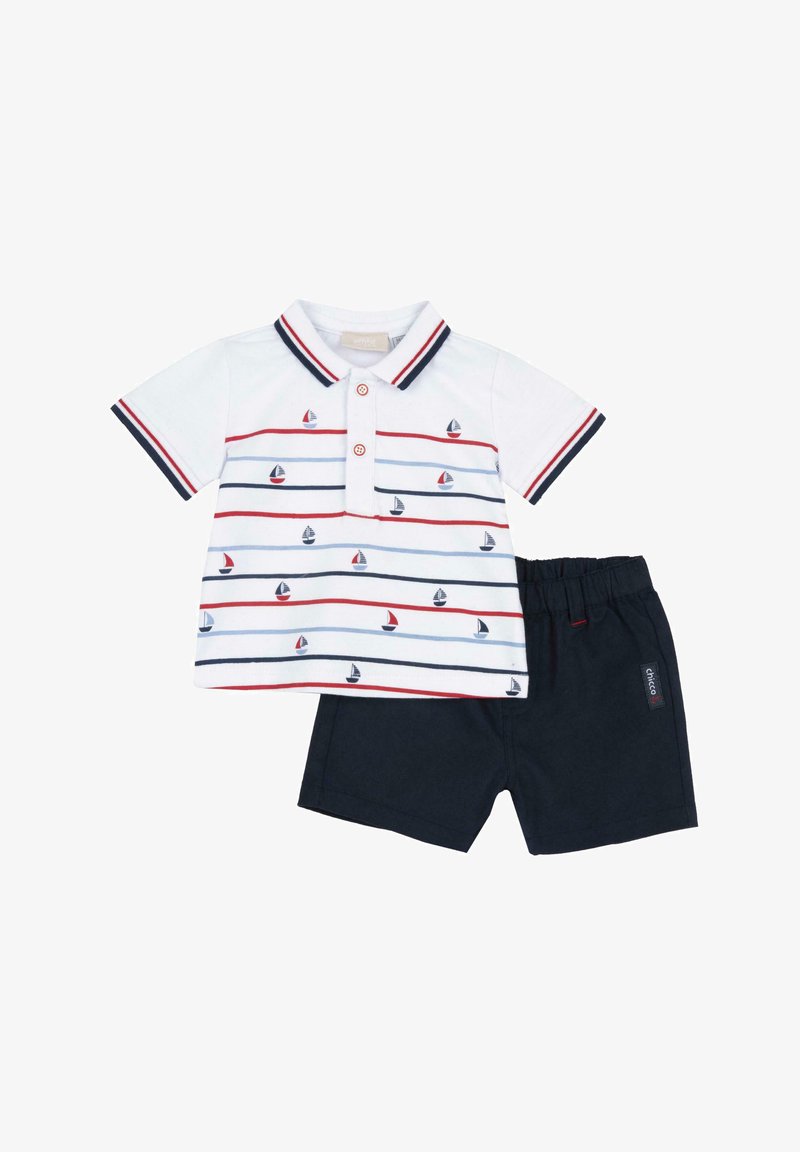 Polo bianco con strisce rosse e blu, con piccoli motivi a veliero; abbinato a pantaloni corti blu navy con elastico in vita e etichetta.