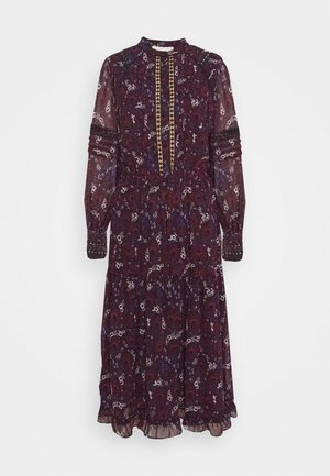 Robe midi à manches longues, col montant, motif violet foncé et noir, avec patte de boutonnage et ourlet volanté sur fond blanc.