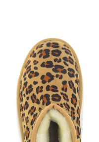 Leopardprint instap schoen met een tan suède-achtige bovenkant, zwarte en bruine vlekken, en een zachte, witte bontvoering zichtbaar bij de opening.