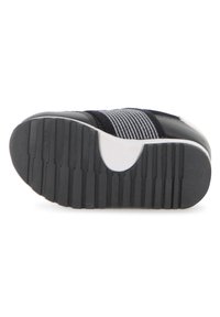 Εξωτερική σόλα παπουτσιού με εύκαμπτη μαύρη καουτσούκ βάση, με οριζόντιες αυλακώσεις, λευκή λεπτομέρεια και επάνω μέρος από υφασμάτινο σχέδιο σε ναυτικό μπλε και γκρι.