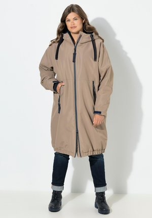 Parka imperméable beige avec fermeture éclair, capuche et cordons bleu marine. Comprend deux poches latérales et un ourlet légèrement élastiqué.