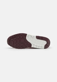Semelle de chaussure avec motif de bande de roulement bordeaux et blanc présentant des formes carrées et en grille texturées pour l'adhérence et la flexibilité.