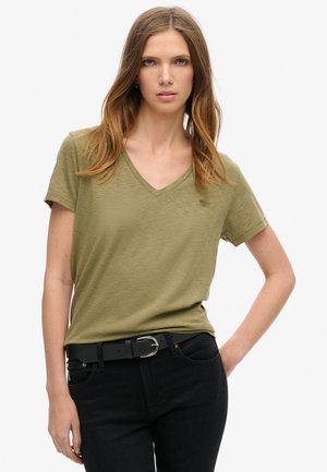 Oliven grøn V-hals t-shirt lavet af blødt stof, med korte ærmer og en subtil logo detalje. Båret med sorte jeans og et sort bælte.