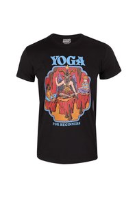 Camiseta de algodón negra con estampado gráfico colorido que muestra la figura de una cabra y dos niños con el texto "YOGA PARA PRINCIPIANTES."