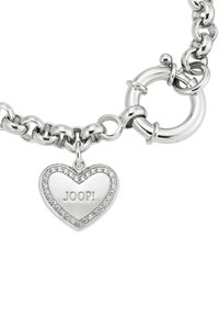 Pulsera de cadena de plata con un charm en forma de corazón con la inscripción "JOOP!" rodeado de pequeñas piedras claras, acabado brillante y cierre redondo.