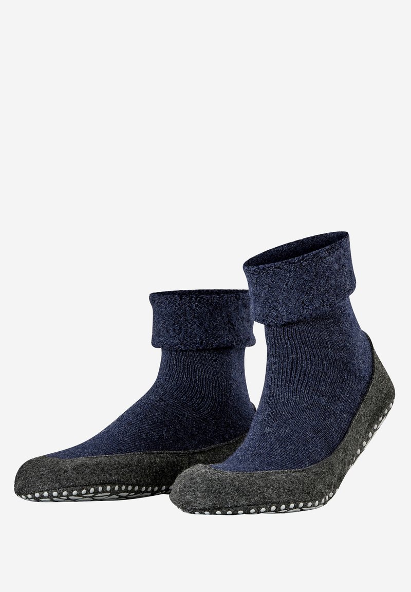Chaussettes en maille bleu marine avec un revers repliable et une semelle extérieure grise texturée dotée d'accents en caoutchouc à points pour une meilleure adhérence.