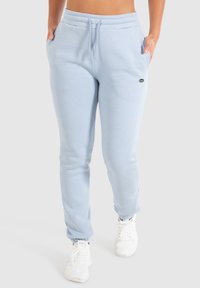 Helle blaue Baumwoll-Sweatpants mit einem elastischen Taillenbund und Kordelzug, ausgestattet mit Seitentaschen und gerippten Bündchen. Kleines Logo auf dem Oberschenkel.