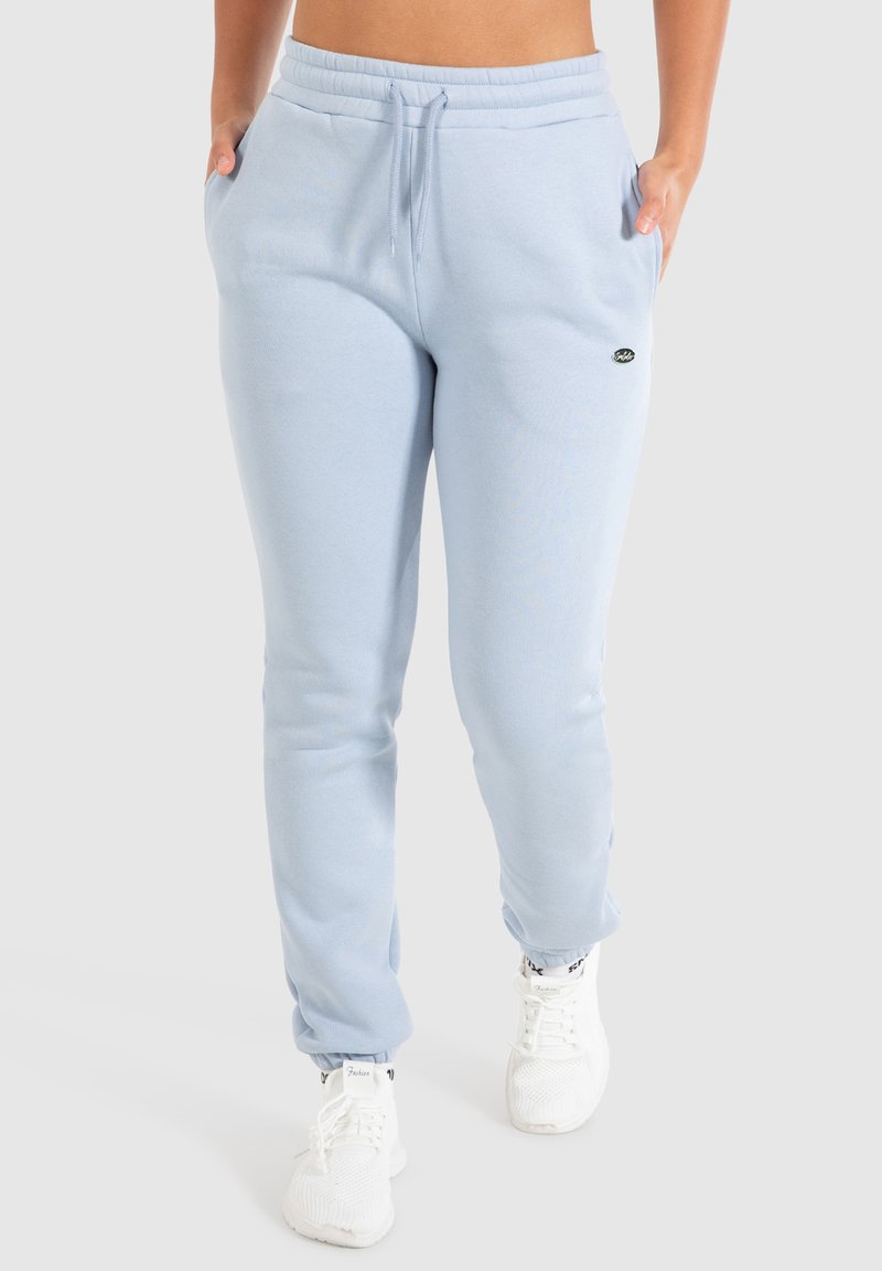 Helle blaue Baumwoll-Sweatpants mit einem elastischen Taillenbund und Kordelzug, ausgestattet mit Seitentaschen und gerippten Bündchen. Kleines Logo auf dem Oberschenkel.